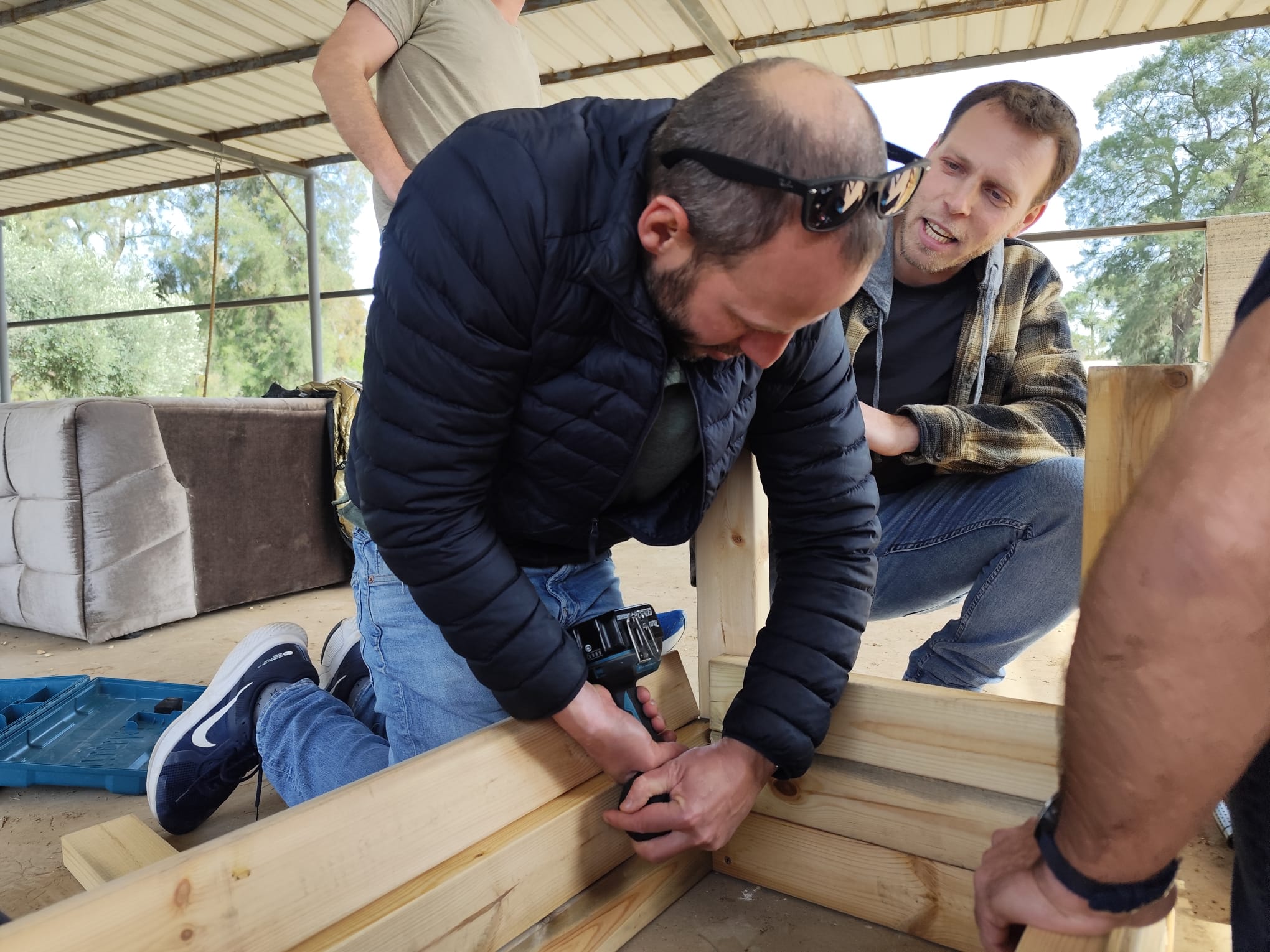 Two men drilling a wooden planter frame together